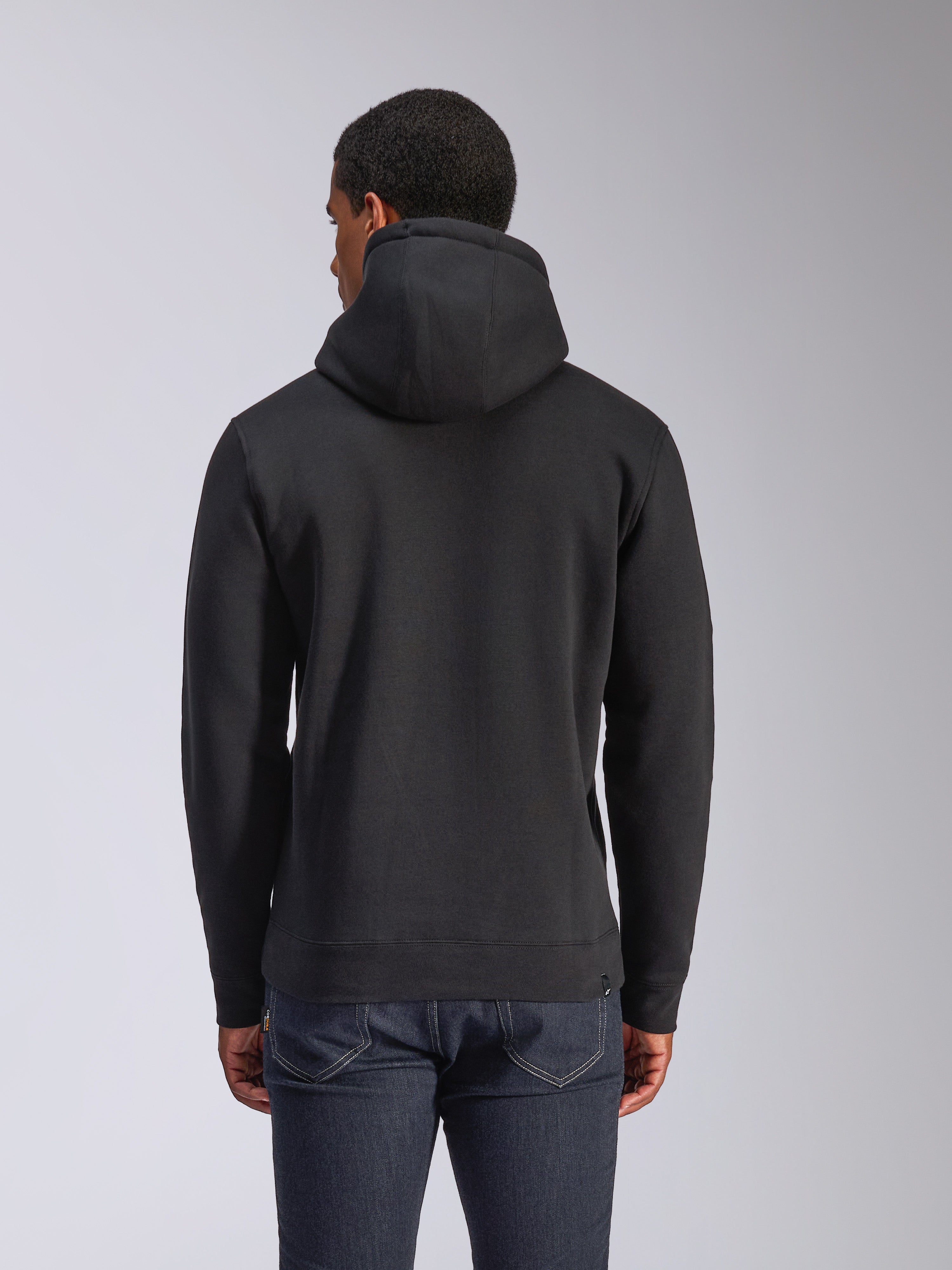 Alpinestars Blaze V3 Hoodie, vista traseira de hoodie preto em fleece, streetwear casual, com punhos e bainha canelados, capuz forrado em jersey, usado com calças de ganga azul escuro