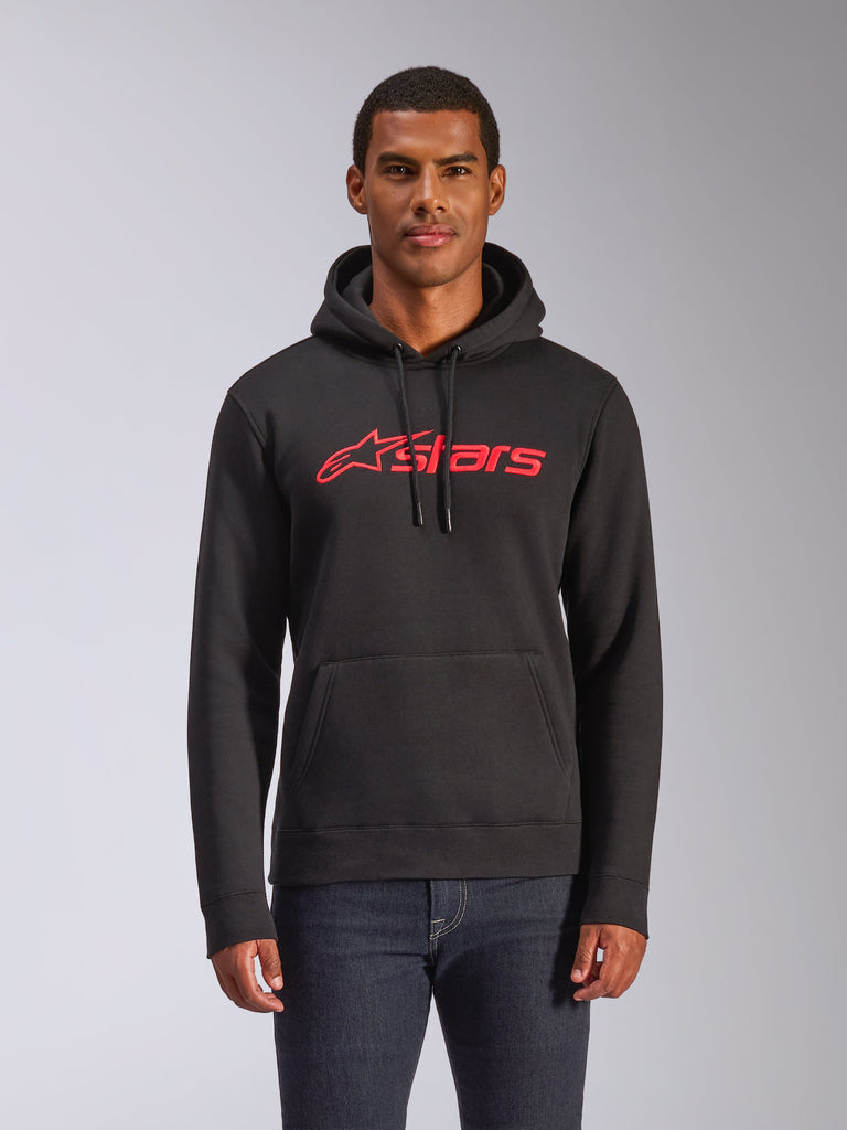 Alpinestars Blaze V3 Hoodie, Men's pullover fleece hoodie, Black with red Alpinestars stars logo, worn by a man with dark jeans, featuring a drawstring hood and kangaroo pocket, casual motorsport-inspired streetwear