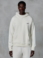 Hoodie Alpinestars Essentials Ageless, off-white, usado por modelo masculino, logótipo pequeno preto no peito, bolso frontal tipo canguru, mangas compridas, streetwear casual inspirado no desporto motorizado
