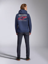 Alpinestars Formulation Hoodie em azul marinho, vista traseira, com grande logótipo Alpinestars a branco e logótipo vermelho com a impressão 'RACING AHEAD', streetwear casual inspirado no desporto motorizado combinado com calças de ganga escuras