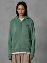 Alpinestars Essentials Ageless Zip Hoodie, verde Cactus, streetwear casual vestido por modelo feminina, hoodie de fleece com fecho, pequeno logótipo preto no peito, bolsos frontais, corte relaxado para o dia a dia