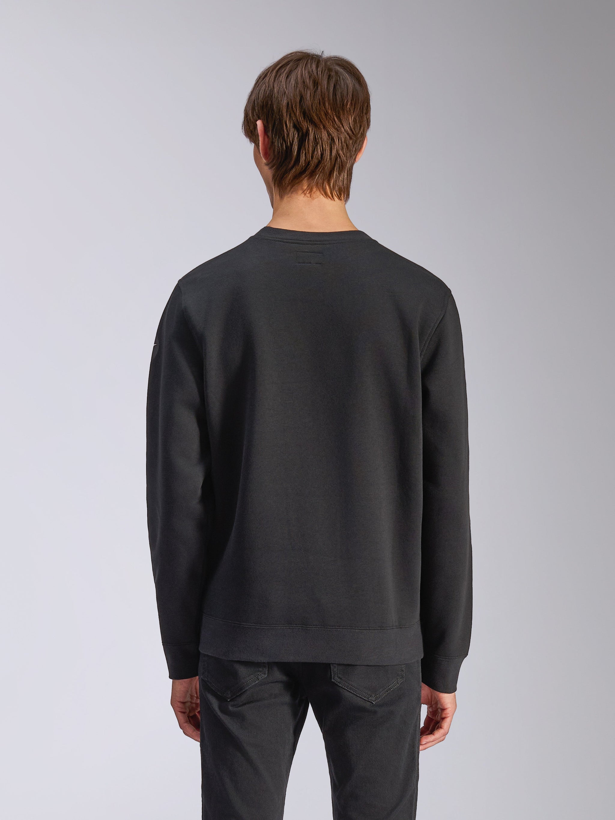 Alpinestars Bettern Crew, camisola de gola redonda, preta, vista traseira no modelo, com punhos e bainha canelados, streetwear casual de desportos motorizados
