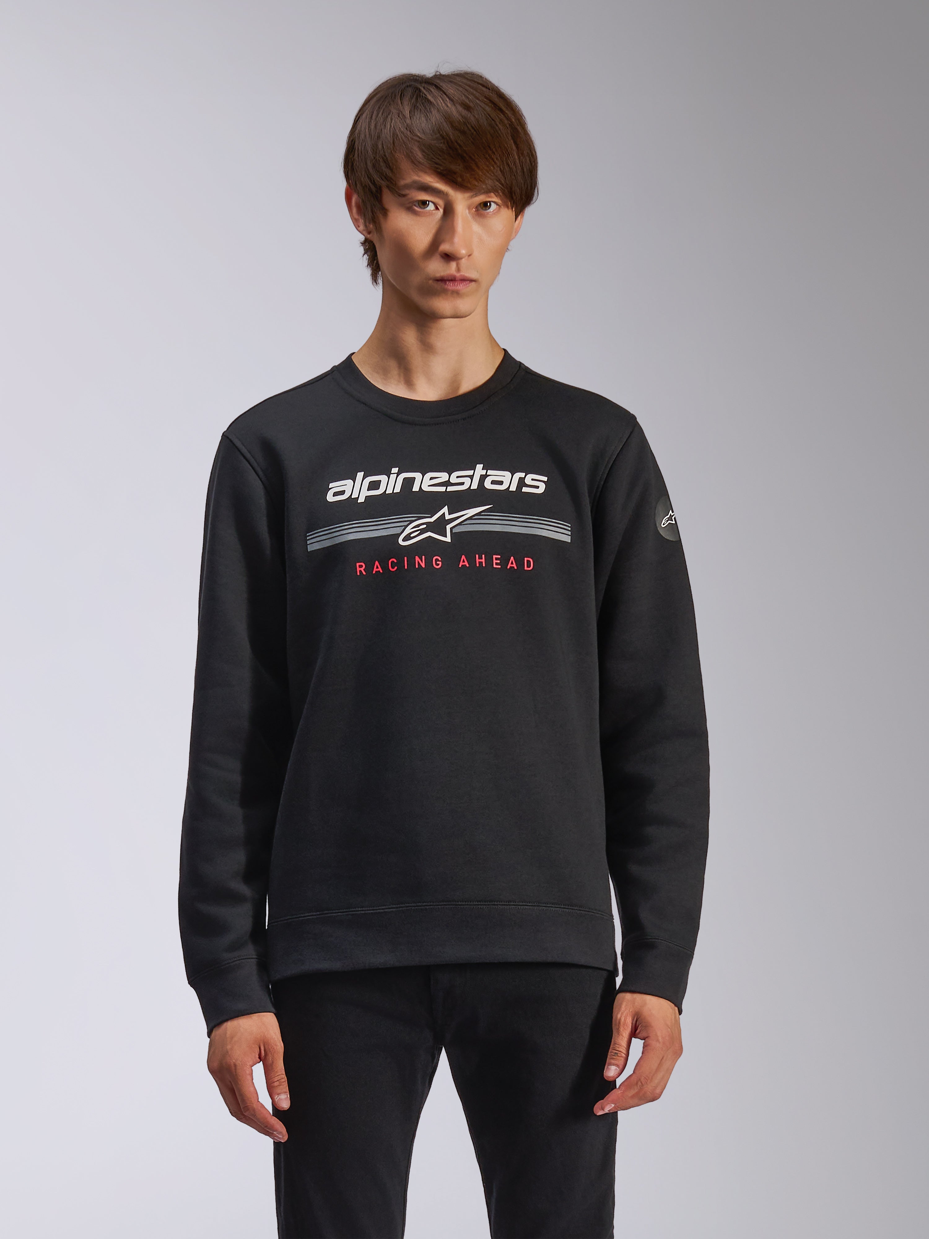 Alpinestars Bettern Crew, camisola de gola redonda, preta, com logótipo Alpinestars a branco, riscas horizontais cinzentas e texto 'RACING AHEAD' a vermelho, streetwear casual de desportos motorizados