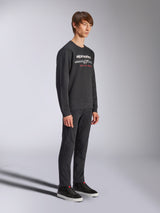 Sweatshirt Alpinestars Bettern Crew, pullover preto de gola redonda, logótipo Alpinestars branco com 'RACING AHEAD' a vermelho no peito, combinado com calças pretas e ténis, streetwear casual inspirado no desporto motorizado
