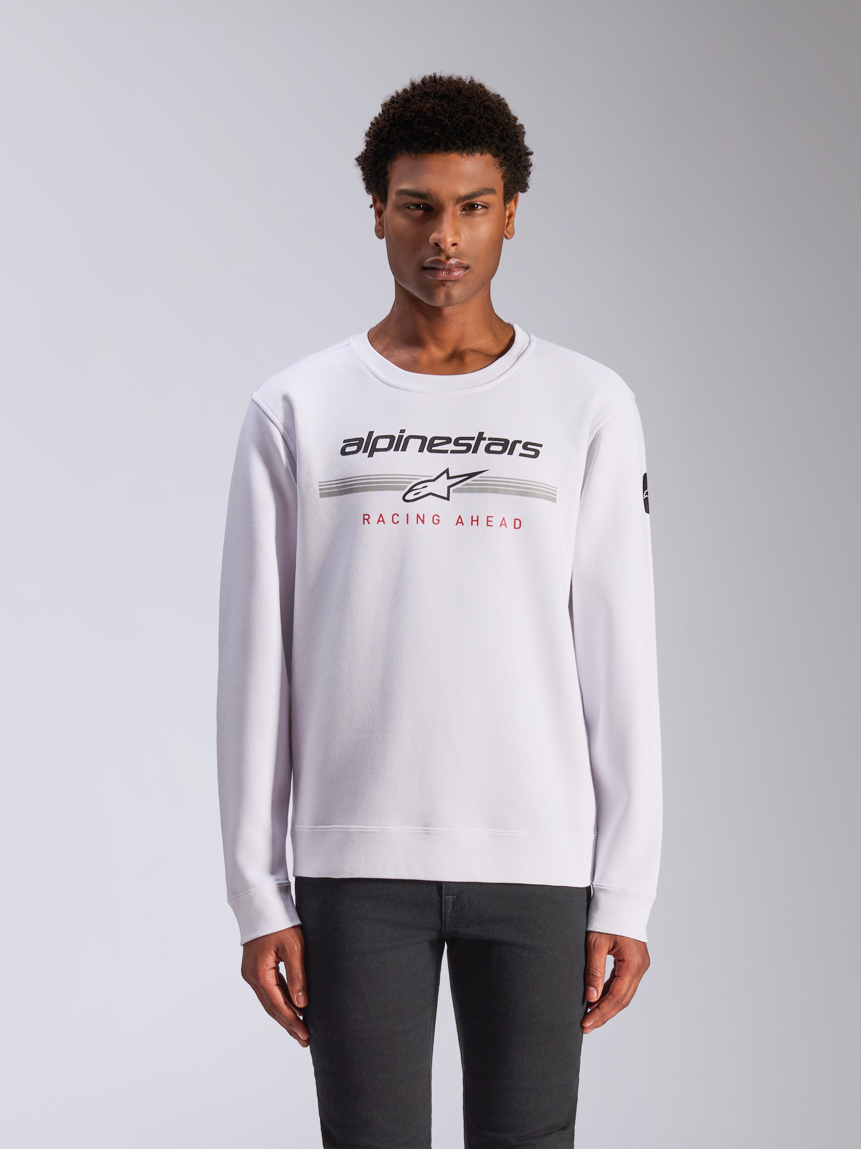 Alpinestars Bettern Crew, sweatshirt de gola redonda, branca, com logótipo Alpinestars preto, listas horizontais cinzentas e texto 'RACING AHEAD' a vermelho, streetwear casual de desportos motorizados