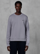 Alpinestars Essentials Ageless Crew, sweatshirt prateada de gola redonda vestida por um modelo, com um pequeno logótipo de estrela preto no peito, corte descontraído com punhos e bainha canelados, streetwear casual de desportos motorizados