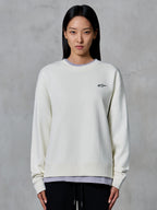Alpinestars Essentials Ageless Crew, sweatshirt de gola redonda, off white, com um pequeno logótipo preto da Alpinestars no peito, vestuário de estilo de vida casual modelado numa mulher