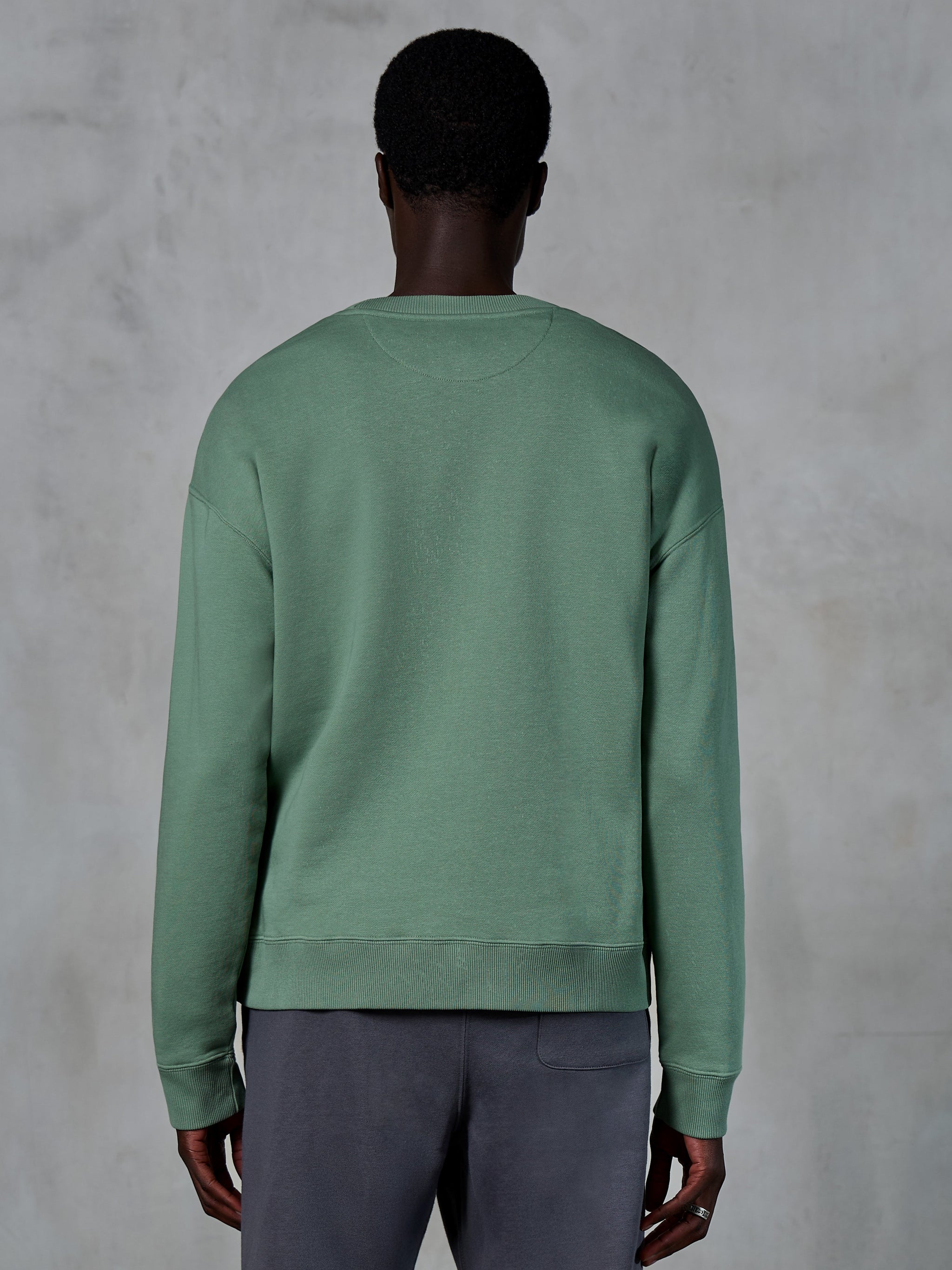 Alpinestars Essentials Ageless Crew, sweatshirt de gola redonda, verde Cactus, vista traseira num modelo, punhos e bainha canelados, fleece compacto premium, estilo casual lifestyle streetwear