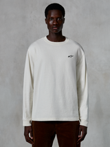 Alpinestars Essentials Ageless LS Tee, t-shirt de manga comprida, Off White, pequeno logótipo de estrela preto no peito, streetwear casual, corte relaxado, vestida por um modelo