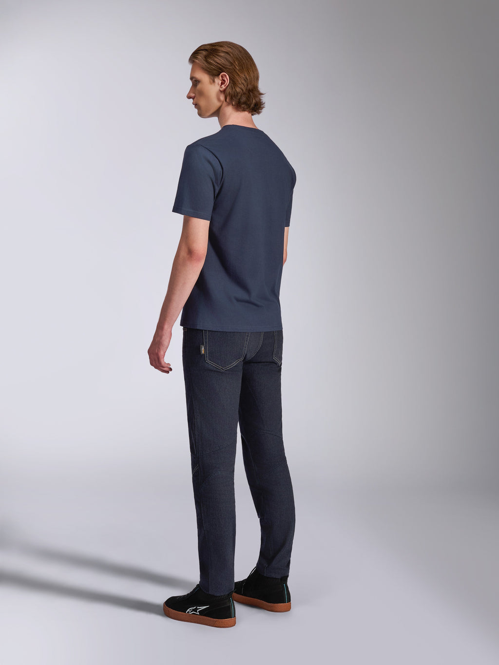 Alpinestars Fasting CSF Tee, t-shirt de manga curta, azul marinho, vista traseira no modelo, combinada com calças de ganga escuras e sapatilhas pretas, streetwear casual inspirado no desporto motorizado