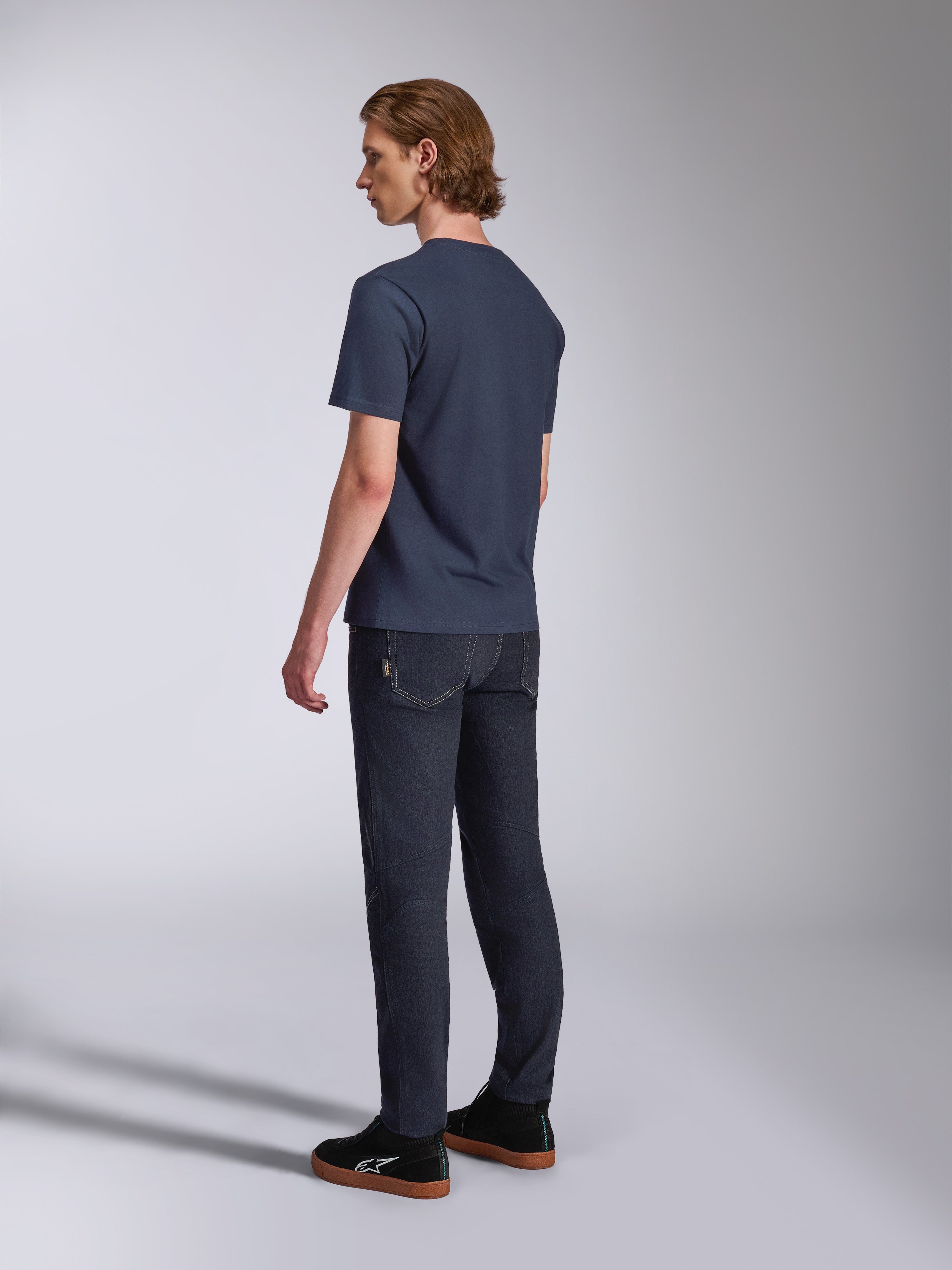 Alpinestars Fasting CSF Tee, t-shirt de manga curta, azul marinho, vista traseira no modelo, combinada com calças de ganga escuras e sapatilhas pretas, streetwear casual inspirado no desporto motorizado