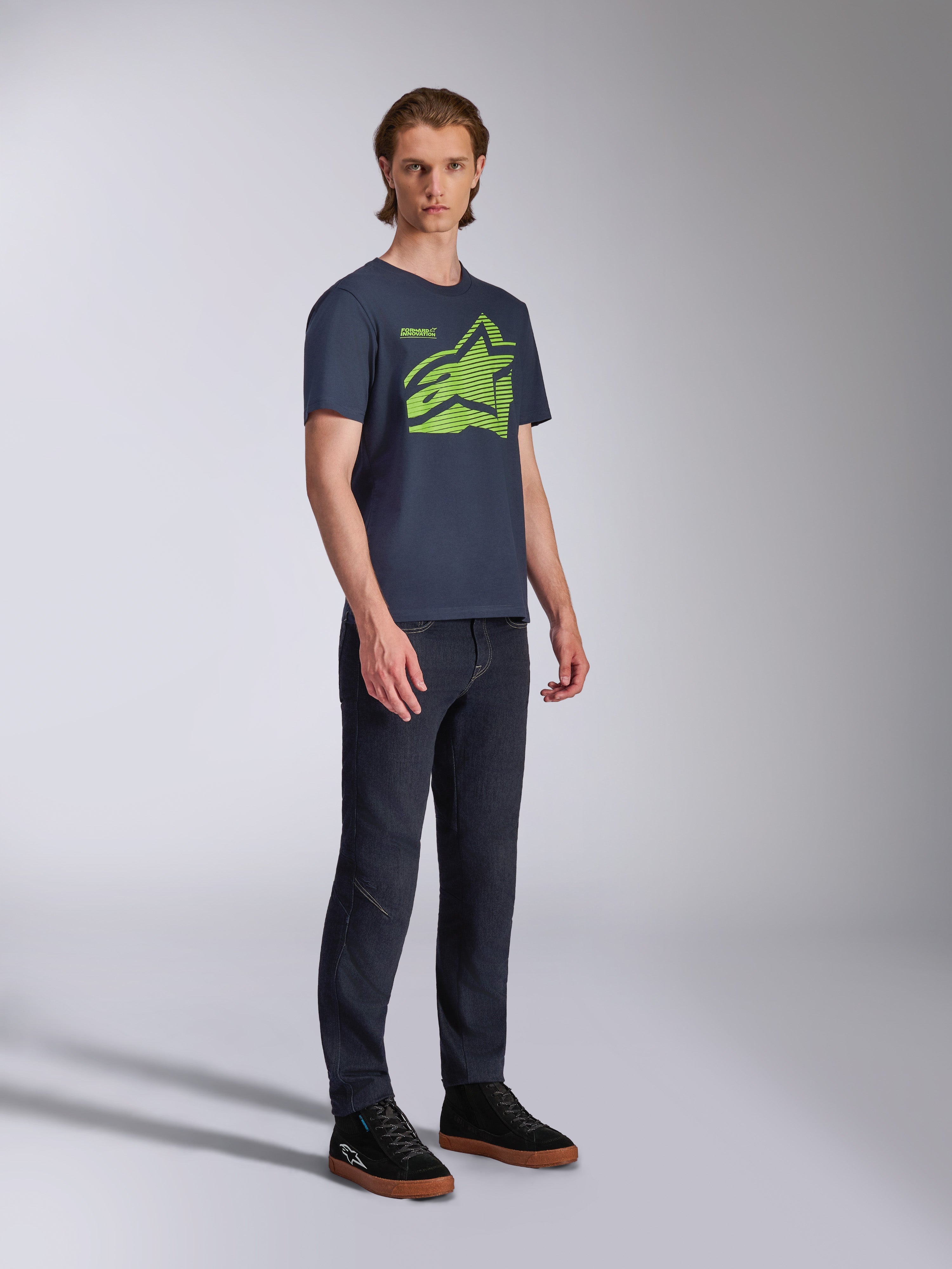 T-shirt Alpinestars Fasting CSF, t-shirt de manga curta, azul marinho, logótipo Astars geométrico em verde lima, usada com calças de ganga escuras e sapatilhas pretas, streetwear casual de desportos motorizados