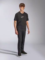 Alpinestars Frontal CSF Tee, t-shirt de manga curta, preta, logótipo Astars branco no peito, vestida por um modelo com calças de ganga escuras e sapatilhas pretas, streetwear casual de performance