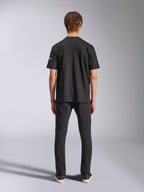 Alpinestars Frontal CSF Tee, t-shirt de manga curta, preta, vista traseira de modelo a usar calças de ganga pretas, streetwear casual de performance com detalhe de pequeno logótipo branco na manga