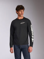 T-shirt de Manga Comprida Alpinestars Trackside CSF, preta, logótipo Alpinestars branco no peito e marca na manga, usada por um modelo com calças de ganga azuis, streetwear casual de desportos motorizados