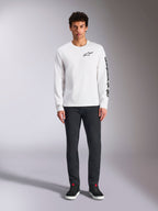 Alpinestars Trackside CSF Tee - Long Sleeve, White with Black branding, small logo on chest and vertical text on sleeve, worn by model with dark pants and black sneakers, casual motorsport-inspired streetwear