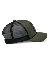 Boné Trucker Booted Alpinestars, Verde Militar com parte traseira em malha preta, vista lateral mostrando a aba curva e o acabamento em corda entrançada, acessório casual inspirado no desporto motorizado