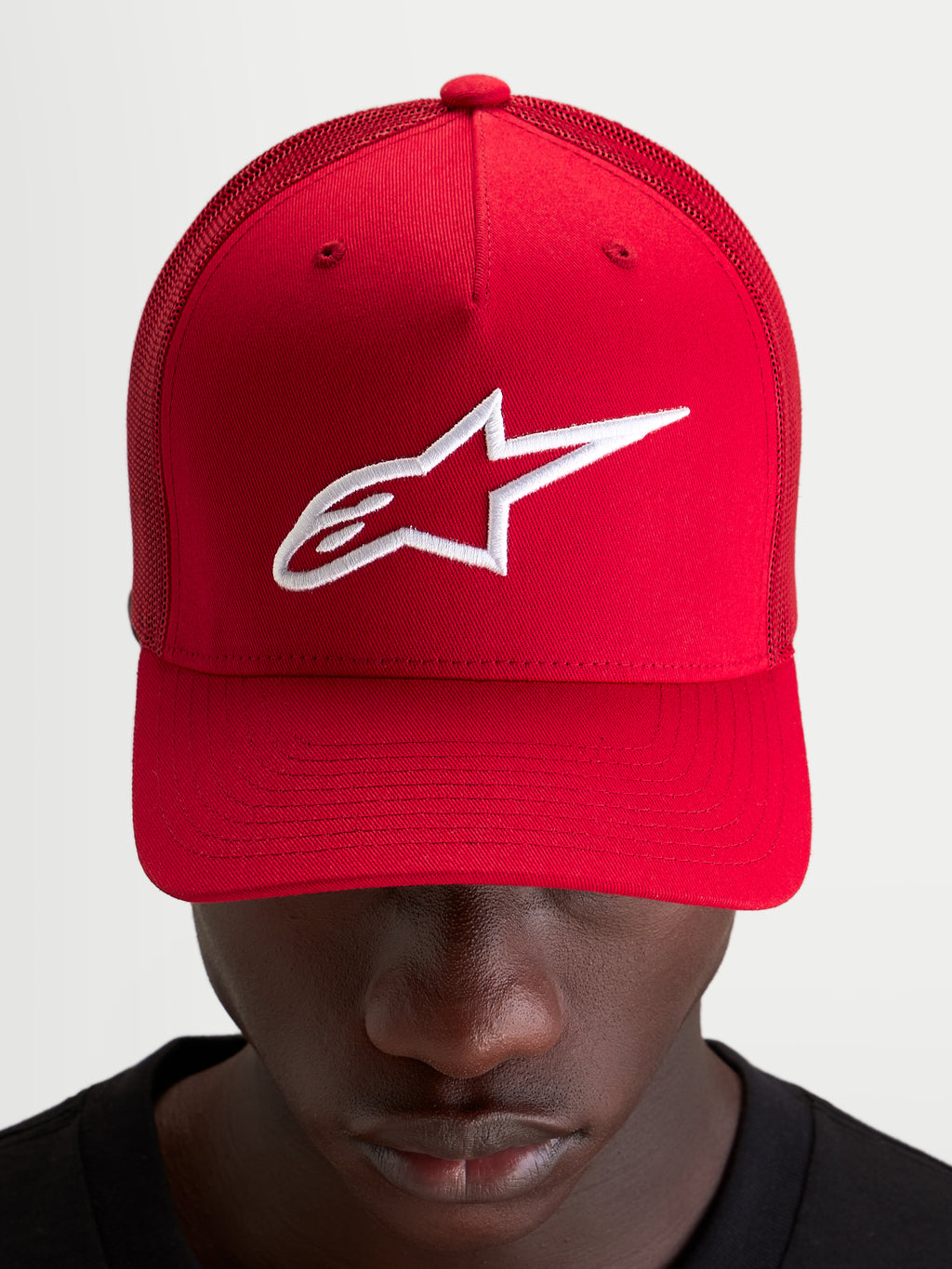 Alpinestars Boné Ageless Snapback, boné sportswear vermelho com logótipo Astars bordado a branco, coroa estruturada e pala curva worn by a model