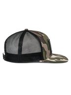 Boné Alpinestars Flag Flat Trucker, camuflado verde e preto, perfil lateral com pala plana camuflada, frente estruturada, parte traseira em malha respirável preta, fecho snapback, acessório casual de desportos motorizados