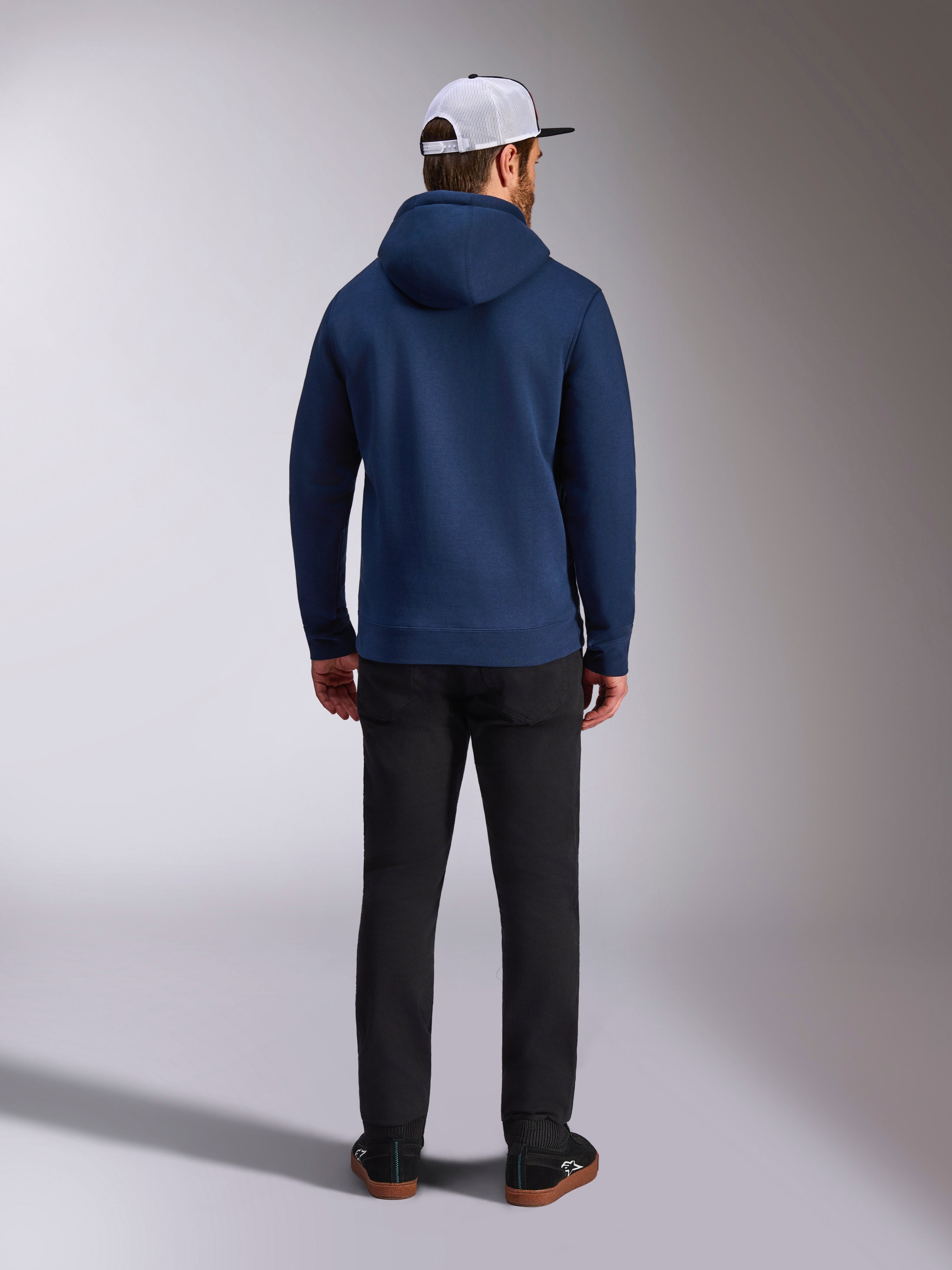Alpinestars Frontal Hoodie, azul marinho, vista traseira de um homem a usar um hoodie casual em lã polar, com punhos e bainha canelados, combinado com calças pretas e um boné de rede branco, streetwear inspirado no desporto motorizado