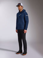 Alpinestars Frontal Hoodie em azul marinho, hoodie pullover casual de lã polar com logótipo Astars branco no peito e logótipo da marca na manga, combinado com boné trucker e calças pretas, vestuário lifestyle moderno inspirado no desporto motorizado