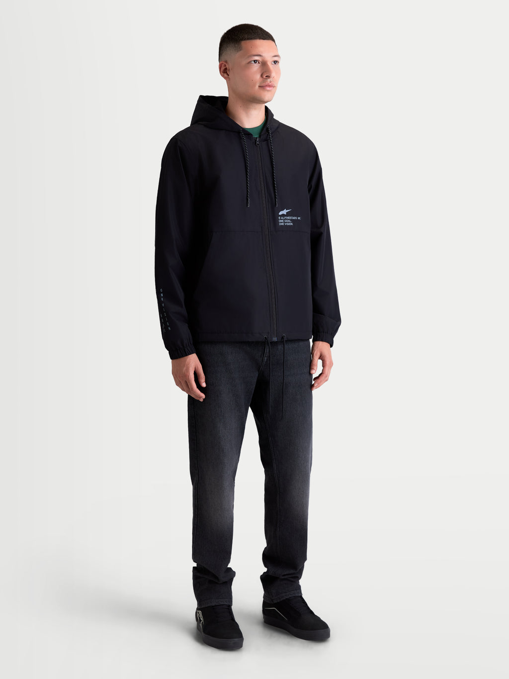 Alpinestars Casaco Corta-Vento Speeder Resolve, casaco corta-vento leve para homem, preto, com capuz ajustável, forro em malha e logótipo motorsport no peito, mostrado em modelo para camadas urbanas.