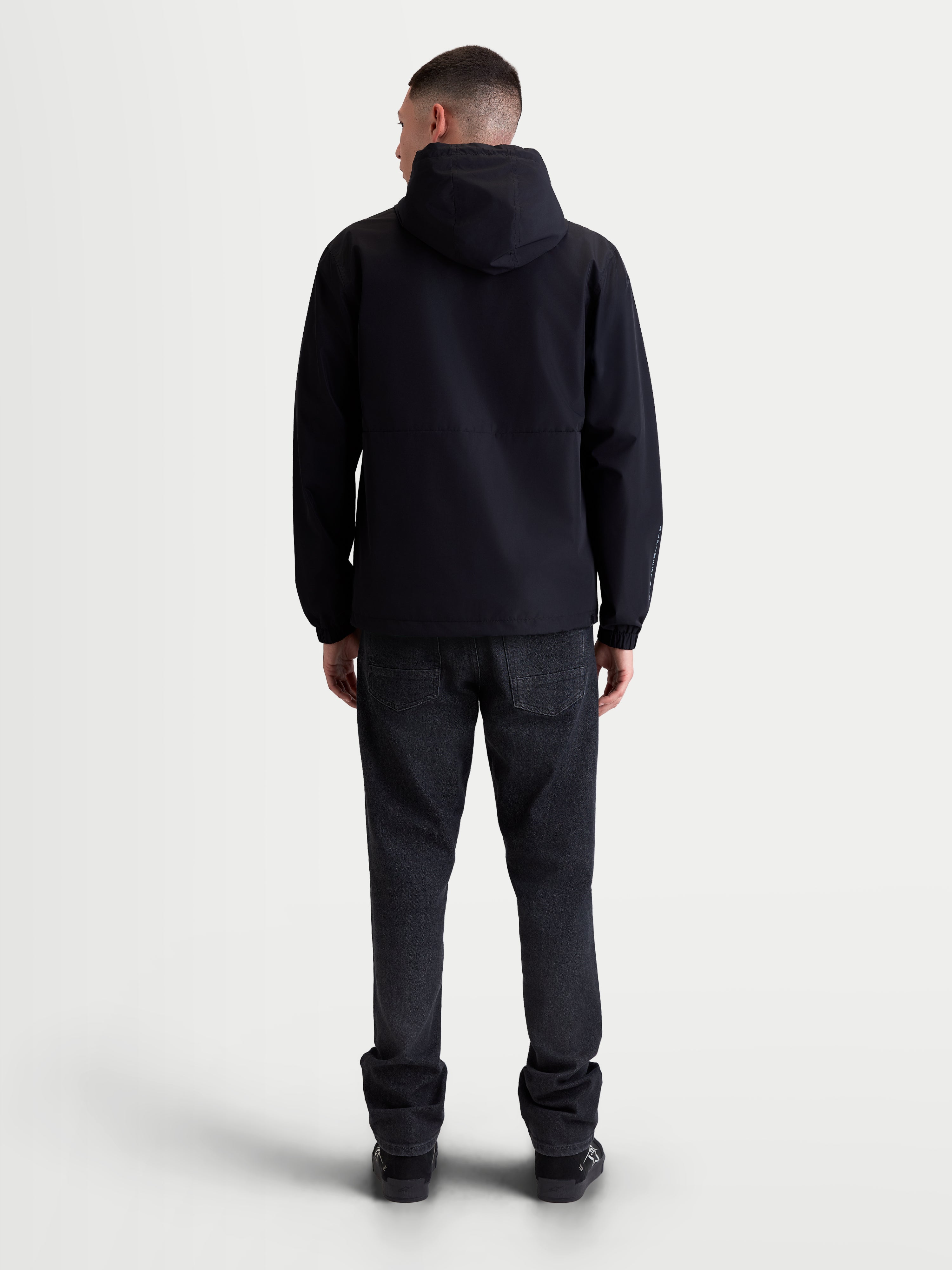Alpinestars casaco corta-vento Speeder Resolve, corta-vento leve para uso urbano, unissexo, preto, vista traseira no modelo, construção respirável com forro em malha, capuz e bainha ajustáveis