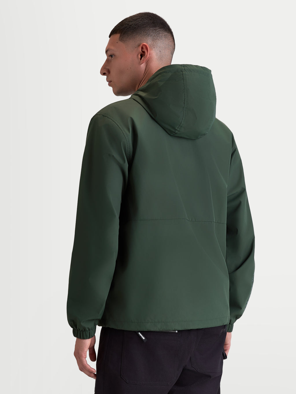 Alpinestars Speeder Resolve, casaco corta-vento de sportswear leve para uso urbano, verde, vista traseira num modelo realçando o design limpo das costas e os punhos elásticos, 100% poliéster com forro em malha.