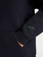 Alpinestars Guise Oversized Crew, Black Sportswear Fleece Pullover, detailed view showing the sleeve with a teal embroidered Astars logo, ribbed cuff, and kangaroo pocket entry, premium cotton and recycled polyester blend sweatshirt.