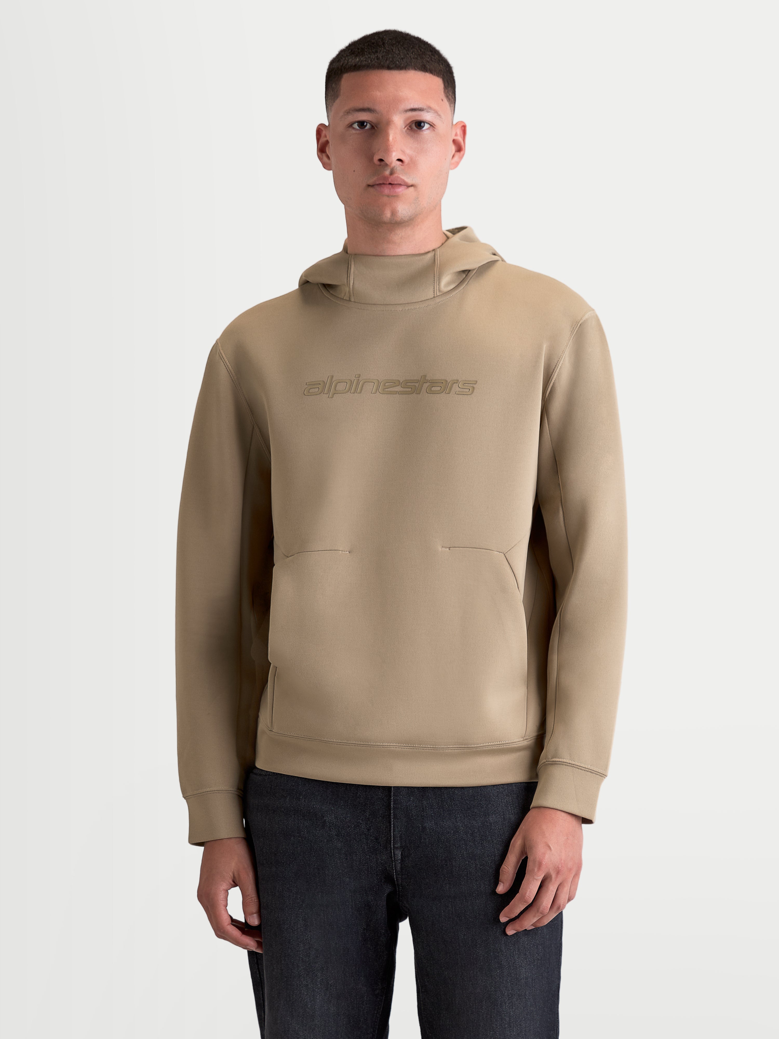 Alpinestars Camisola com capuz Datrix, hoodie de sportswear para homem e mulher, castanho, com branding tonal Alpinestars, capuz forrado em malha e construção em fleece de dupla face, estilo casual inspirado no motorsport, modelo a vestir o artigo.