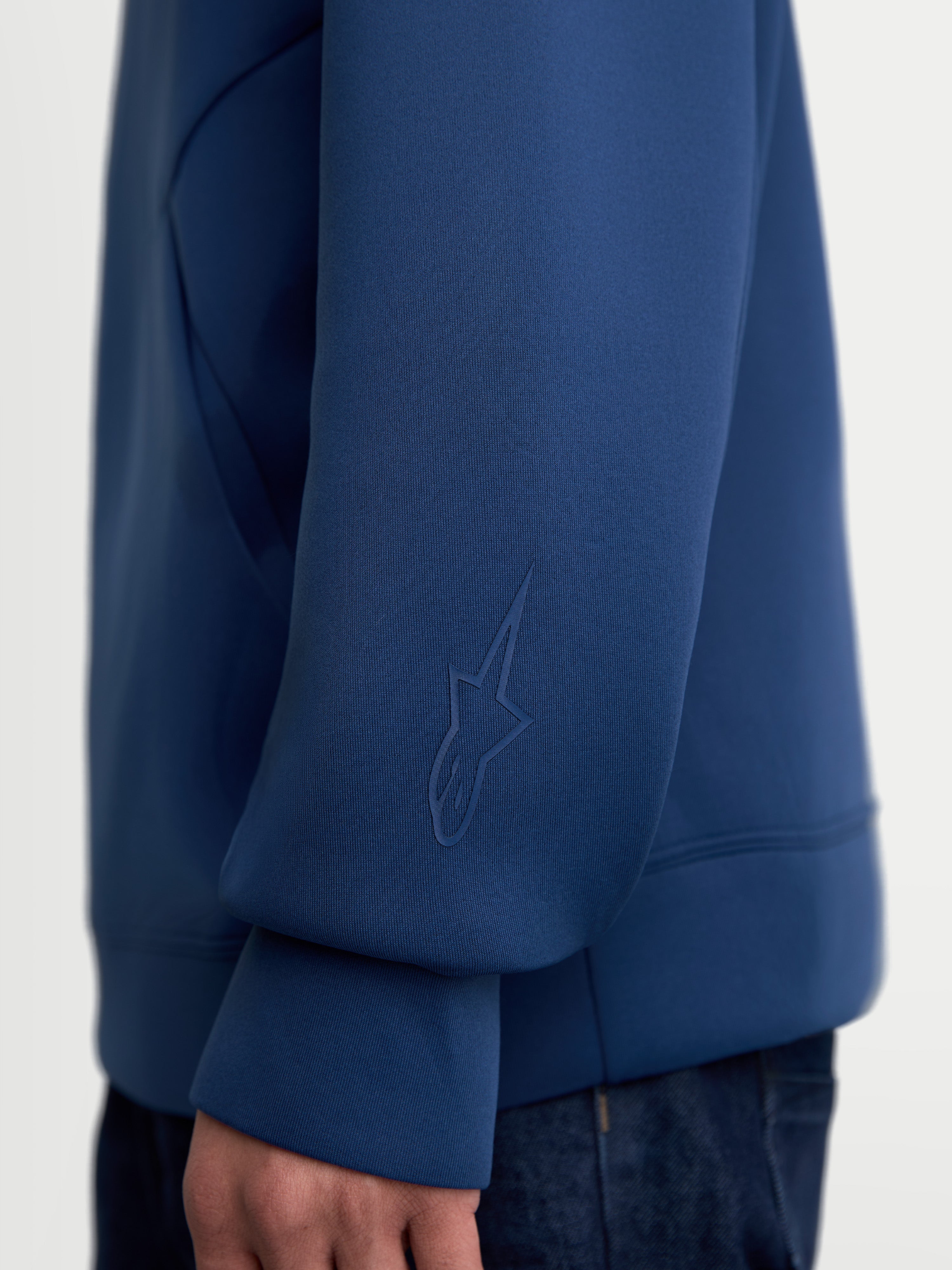 Alpinestars Camisola com capuz Datrix, pullover de sportswear premium, azul, vista de pormenor da manga com logótipo Alpinestars tonal em HD, tecido fleece tri-blend de dupla face, casual para o dia a dia.