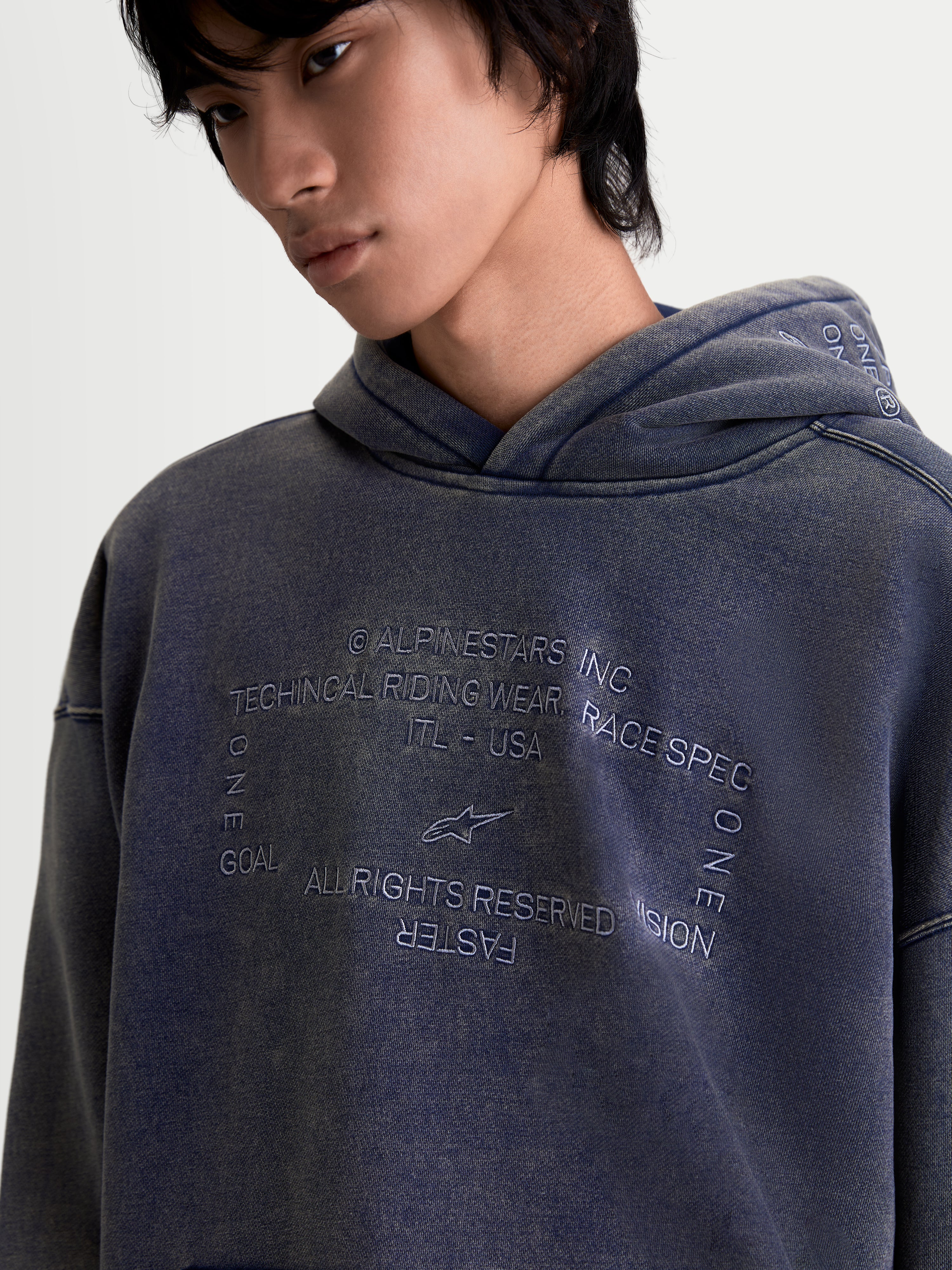 Alpinestars Infinite Washed Oversized Hoodie, camisola com capuz unissexo, azul marinho lavado, pormenor de grafismo bordado detalhado no peito com branding técnico, acabamento snow-wash e construção em fleece, casual sportswear