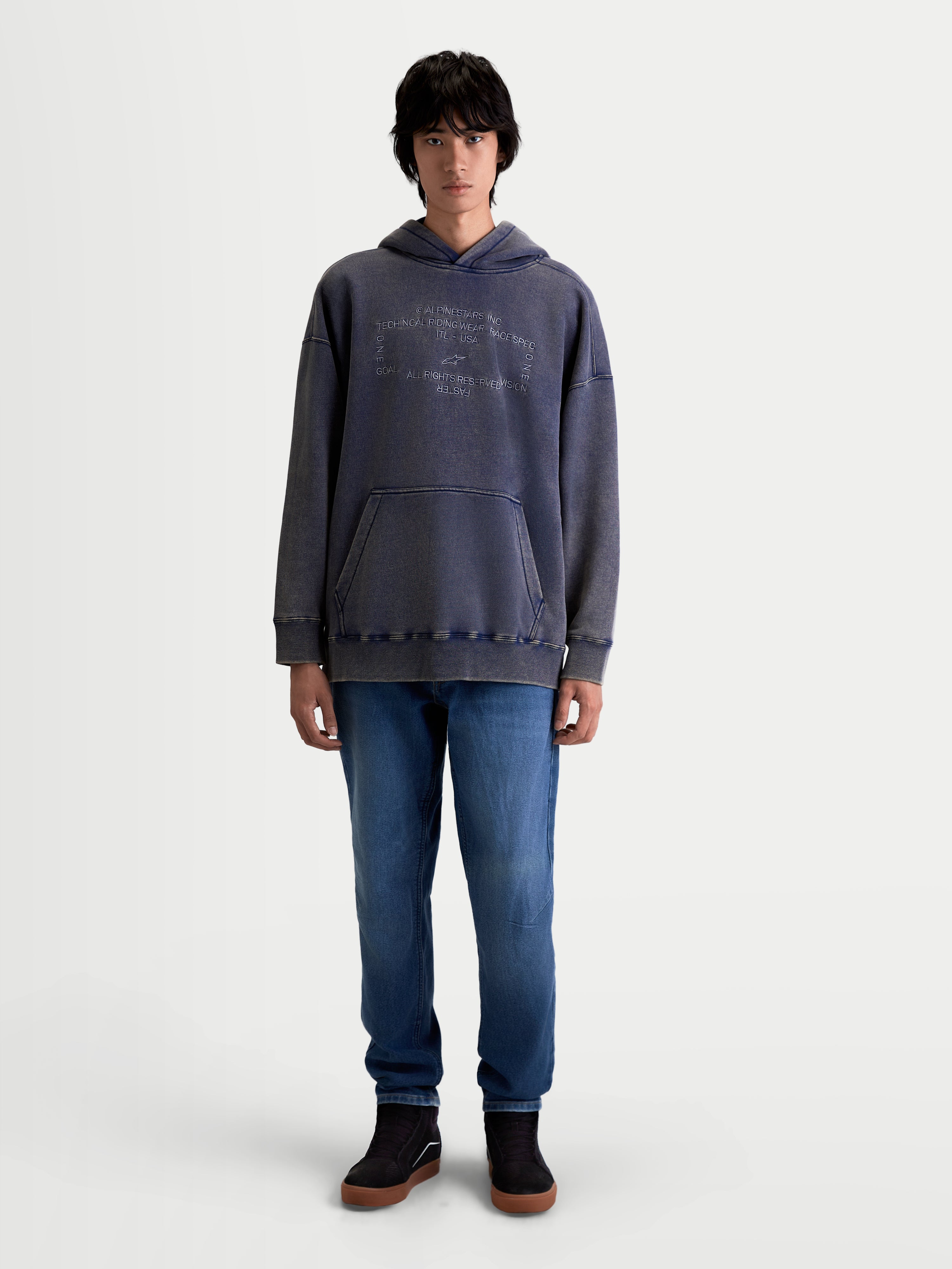Alpinestars Camisola Com Capuz Infinite Washed Oversized, camisola casual de estilo sportswear vestida por um modelo, azul com acabamento snow-wash, bolso canguru frontal e logótipo Alpinestars bordado no peito, silhueta oversized e ajuste relaxado.