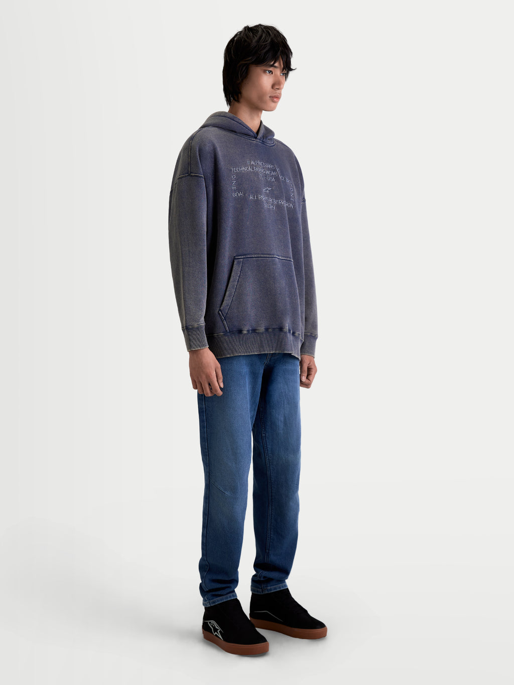 Alpinestars Camisola Com Capuz Infinite Washed Oversized, camisola sportswear unissexo, azul marinho com efeito lavado snow-wash, em fleece com bolso canguru e logótipo bordado, modelo em estúdio.