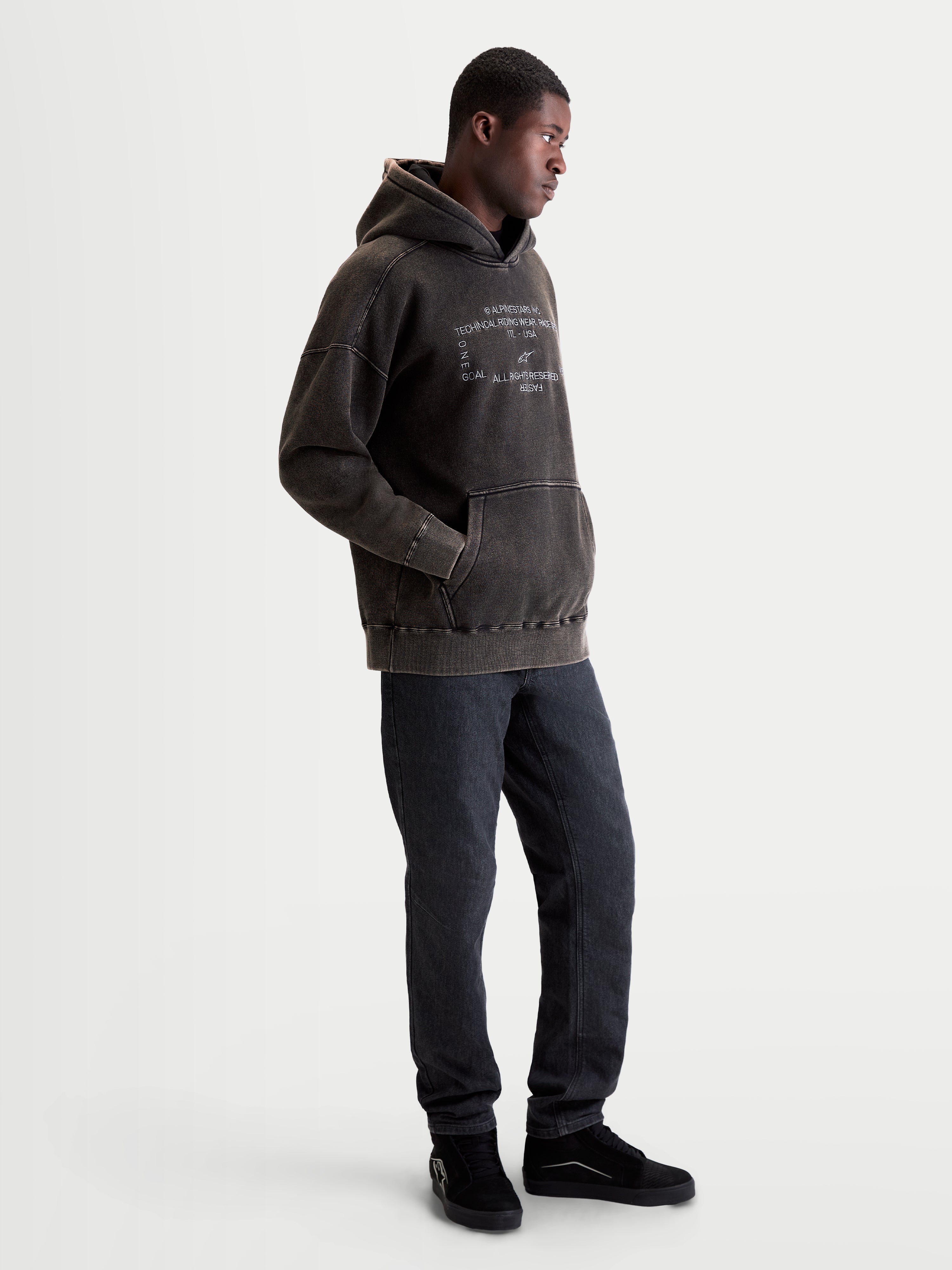 Alpinestars Camisola Com Capuz Infinite Washed Oversized, camisola de sportswear casual para homem, preta com acabamento snow-wash, logótipos bordados a branco no peito e bolso canguru, vista num modelo.