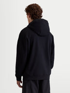 Alpinestars camisola com capuz Shaw Oversized, camisola de sportswear unissexo, preta, vista traseira com ajuste oversized relaxado, material em fleece de algodão e poliéster reciclado com acabamentos canelados.