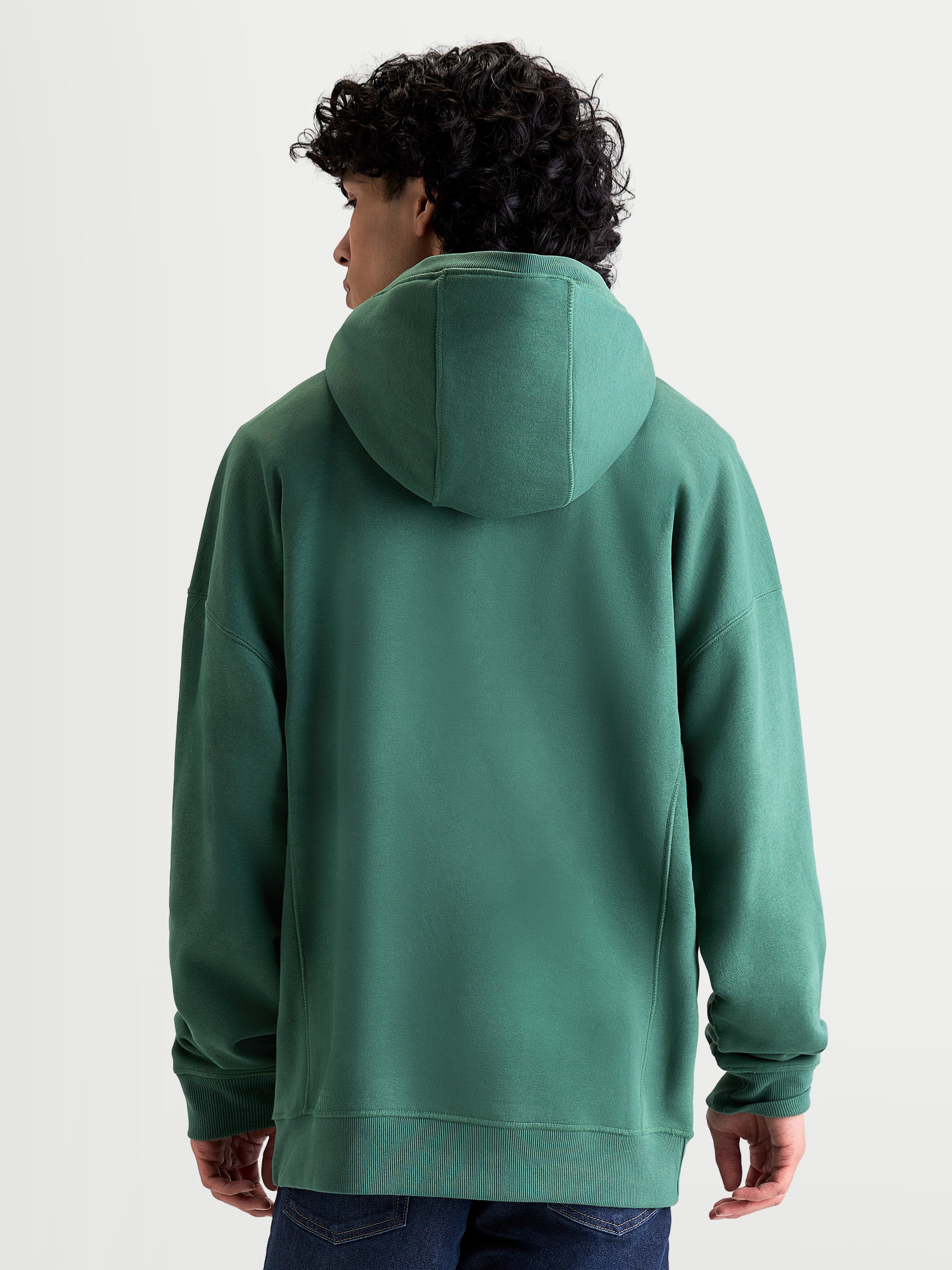 Alpinestars camisola com capuz Shaw Oversized, vista traseira no modelo, verde, ajuste descontraído unissexo, capuz forrado e acabamentos canelados, construção em fleece de algodão e poliéster reciclado, casual sportswear.