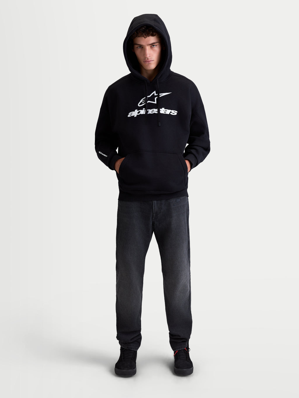 Alpinestars Prelude Oversized Hoodie, camisola com capuz em fleece para sportswear, unissexo, preta e branca, corte relaxado com bolso canguru e logótipos em relevo no peito e na manga, mostrada em modelo.