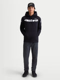 Alpinestars Camisola Com Capuz Velocifier, camisola com capuz para homem, preta, com logótipo Astars branco na frente e nos ombros, sportswear casual para uso fora da moto, modelo a usar boné e calças de ganga.