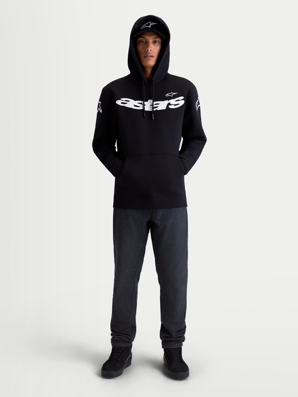 Alpinestars Camisola com capuz Velocifier, hoodie de sportswear unissexo, preta e branca, vista frontal no modelo com logótipo Astars grande no peito e nos ombros, ideal para uso casual fora da moto, mistura de algodão e poliéster reciclado.
