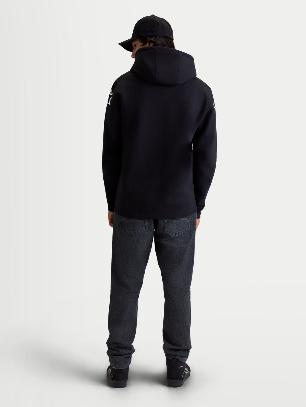 Alpinestars Camisola com capuz Velocifier, hoodie de sportswear para homem em fleece, preto, vista traseira em modelo com capuz e logótipos Alpinestars brancos nos ombros, mistura de algodão e poliéster reciclado.