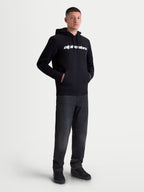 Alpinestars camisola com capuz Race Wordmark, fleece para homem de estilo sportswear, preto e branco, com logótipo linear branco no peito, capuz com cordões e bolso frontal, confeccionada em algodão e poliéster reciclado, vista no modelo.