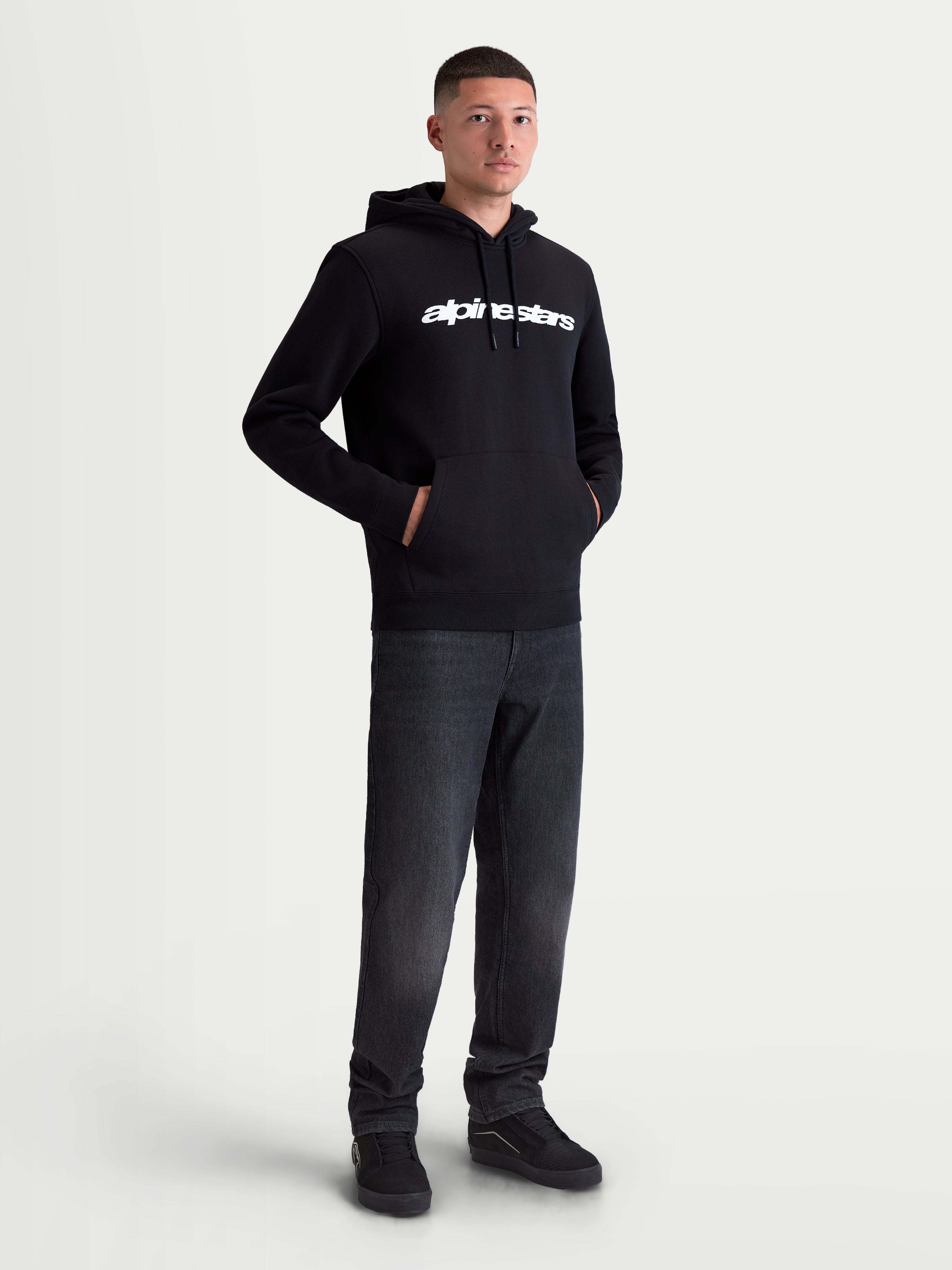 Alpinestars camisola com capuz Race Wordmark, fleece para homem de estilo sportswear, preto e branco, com logótipo linear branco no peito, capuz com cordões e bolso frontal, confeccionada em algodão e poliéster reciclado, vista no modelo.