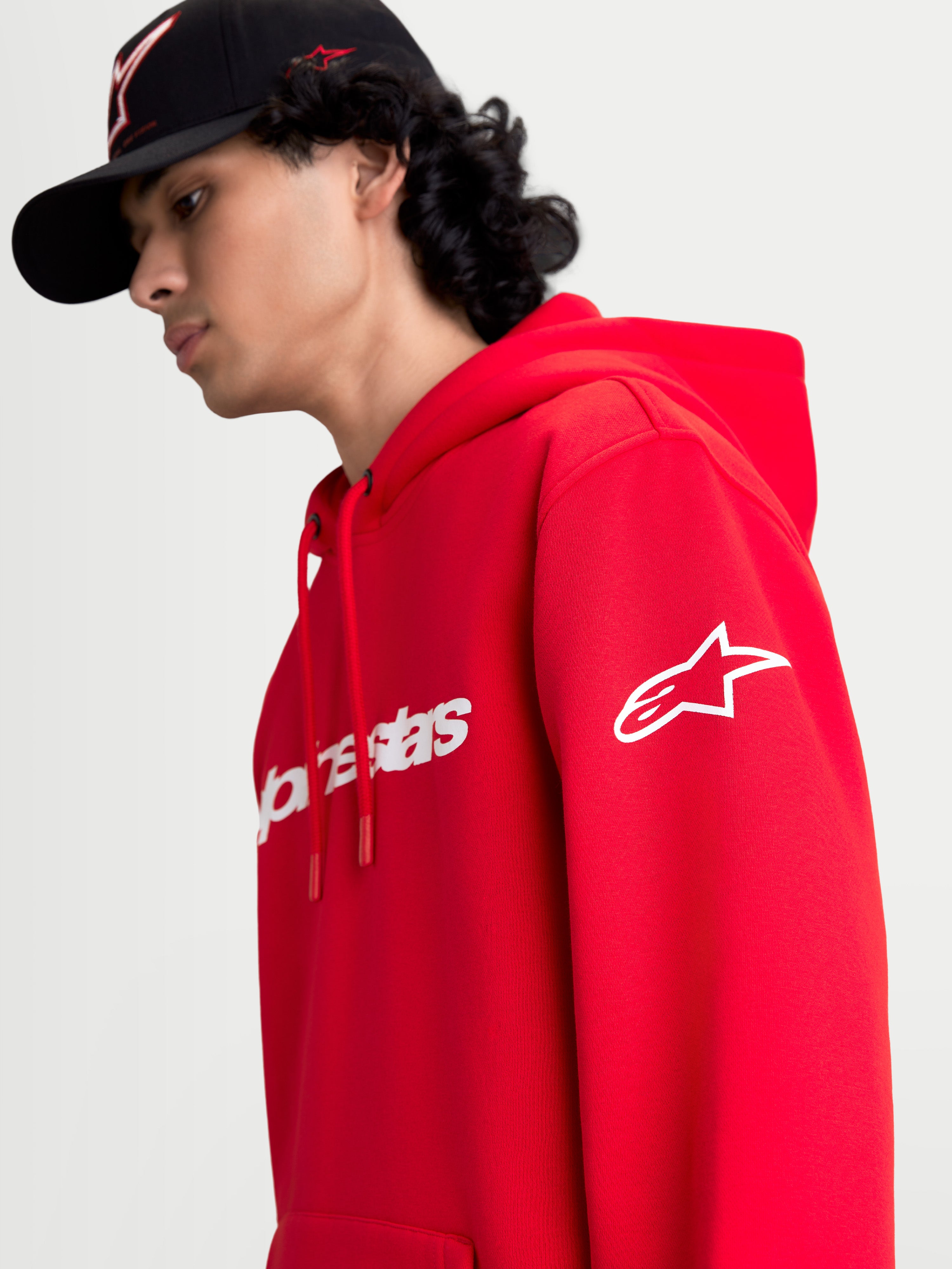 Alpinestars camisola com capuz Race Wordmark, camisola de fleece vermelha e branca, vista lateral em modelo com logótipo Ageless branco na manga e branding Race Linear na frente, design casual inspirado no motorsport.