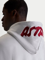 Alpinestars camisola com capuz Pioneer Oversized, casual sportswear em fleece para homem e mulher, cinzento cimento e vermelho, vista de costas no modelo realçando o logótipo bordado no capuz.