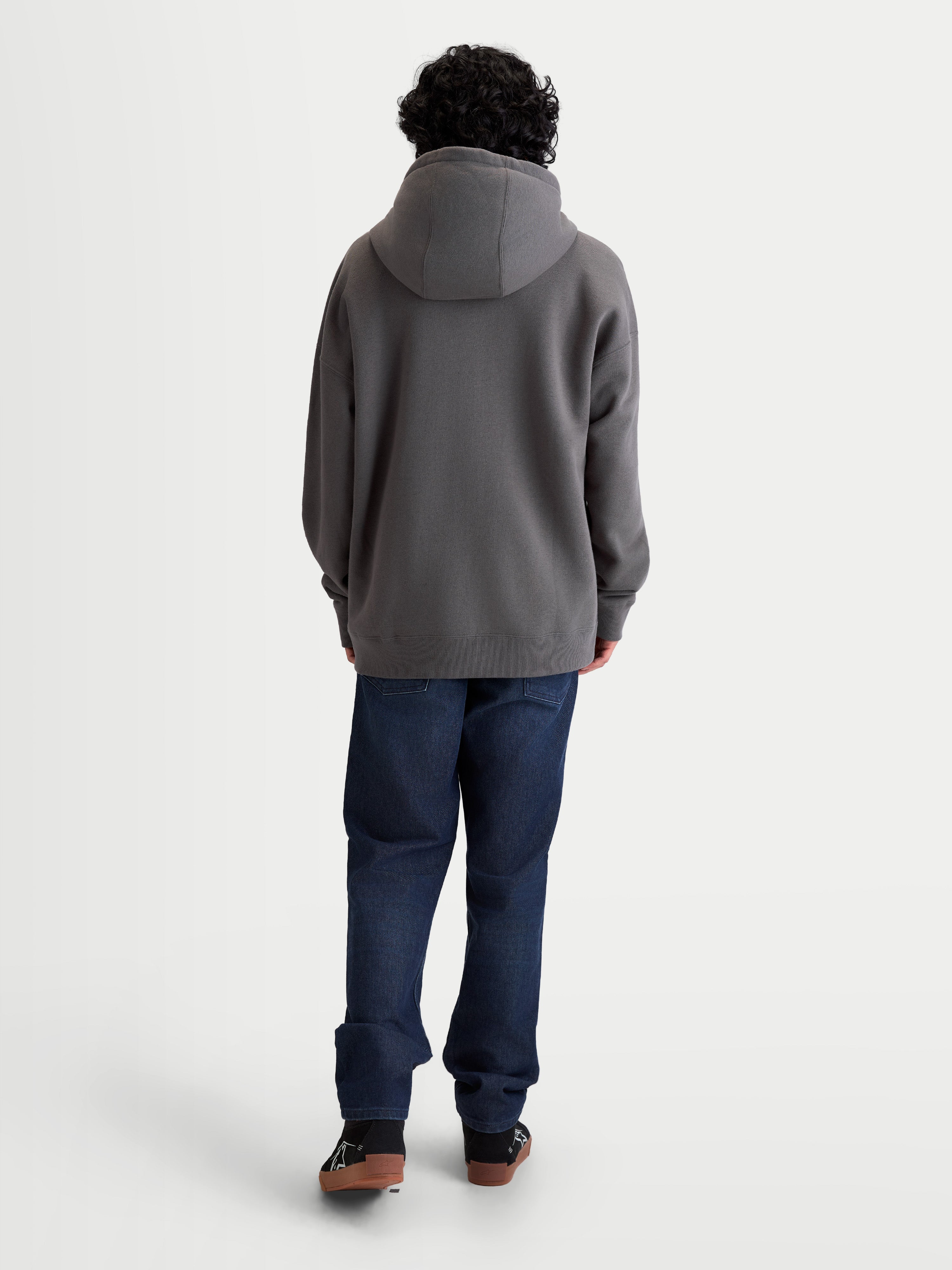 Alpinestars Camisola Com Capuz Entity Oversized, hoodie de desporto em fleece, unissexo, cinzento, vista traseira no modelo com ajuste descontraído, capuz forrado e punhos canelados, em algodão e poliéster reciclado