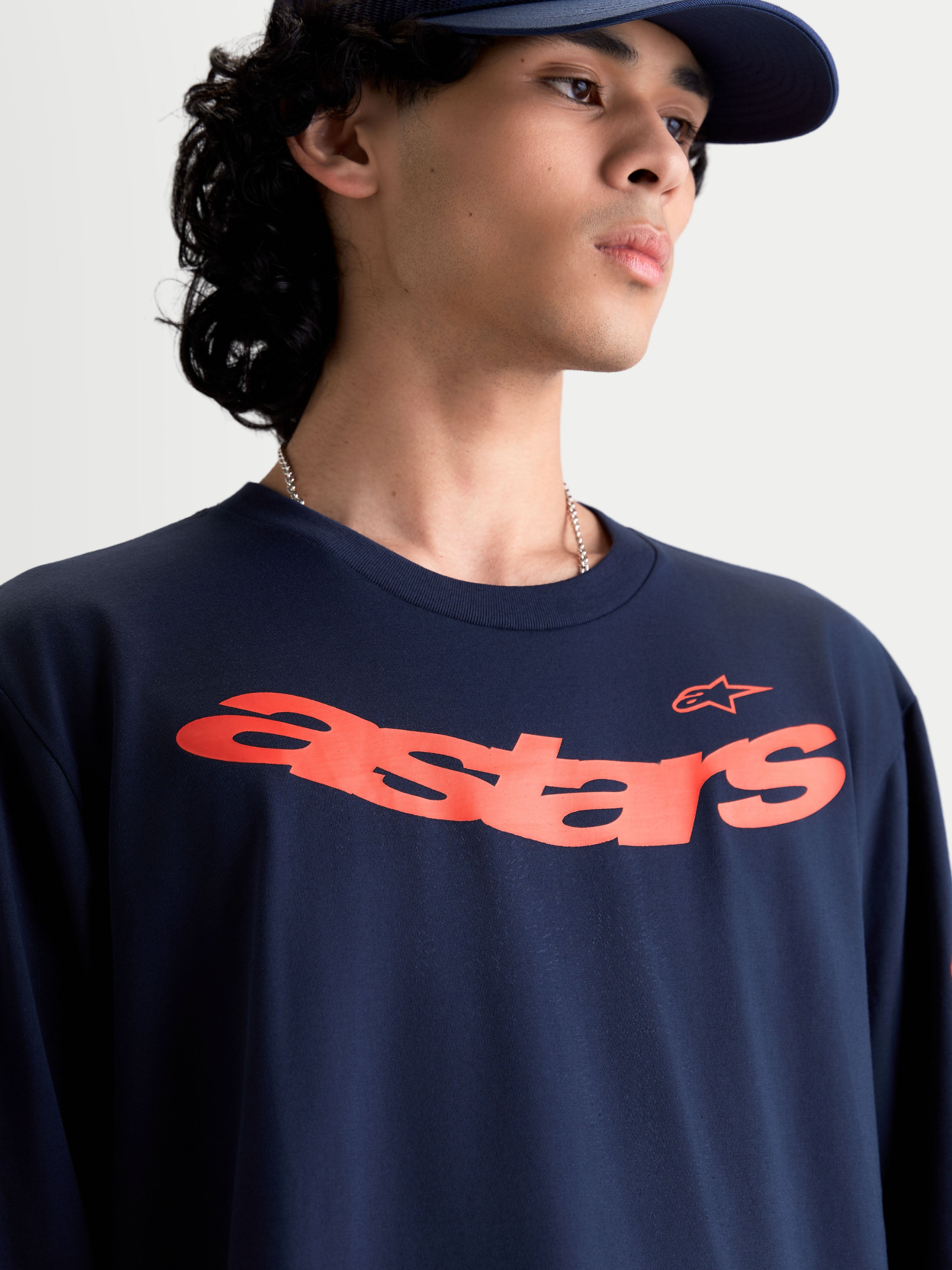 Alpinestars T-shirt Velocifier CSF, t-shirt de manga comprida azul-marinho com gráfico Astars curvo em laranja no peito, sportswear casual inspirado no motorsport em modelo, mistura de algodão suave.