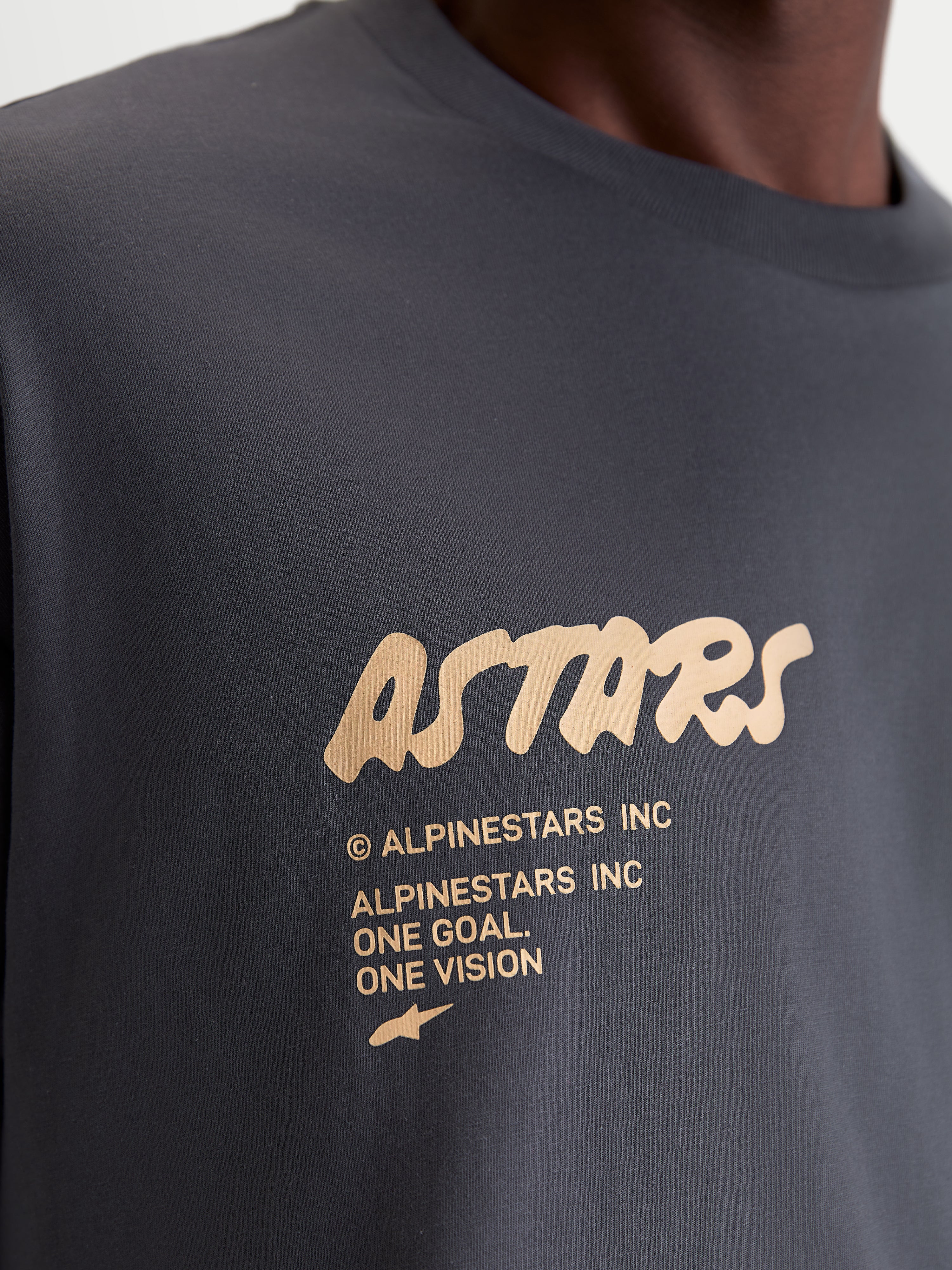 Alpinestars T-Shirt Chalk Oversized CSF, t-shirt de manga curta cinzenta-escura e bege, casual sportswear, pormenor em grande plano do logótipo frontal Astars de toque suave e branding One Goal One Vision, corte oversized.