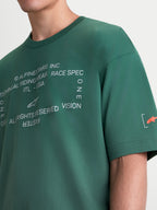 Alpinestars Infinity Oversized CSF Tee, Green Short-Sleeve Sportswear T-Shirt, Unisex, close-up of white technical chest graphic and orange sleeve logo, premium cotton-poly blend.