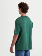Alpinestars Infinity Oversized CSF Tee, Men's Short Sleeve Sportswear T-Shirt, Green, features an oversized fit and cotton-poly blend construction, back view on model showing sleeve logo detailing.